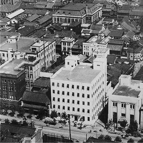 大阪支店（右より二つ目のビル、1935年）。左の大きな黒い建物が本店ビル
